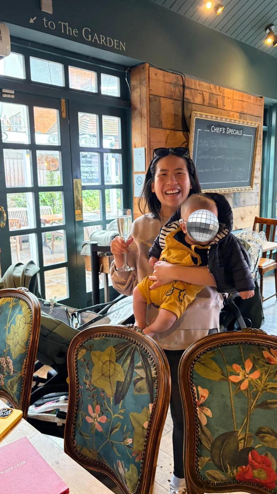celebrating with a glass of fizz and baby in arms